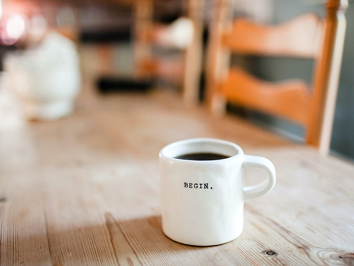 mug off coffee with the words “Begin.” printed on it