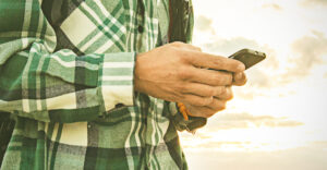 A man in flannel holds his phone