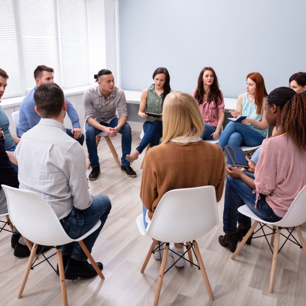 a group meeting - they are sitting in a circle toegether