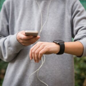 someone checking their smartwatch and phone