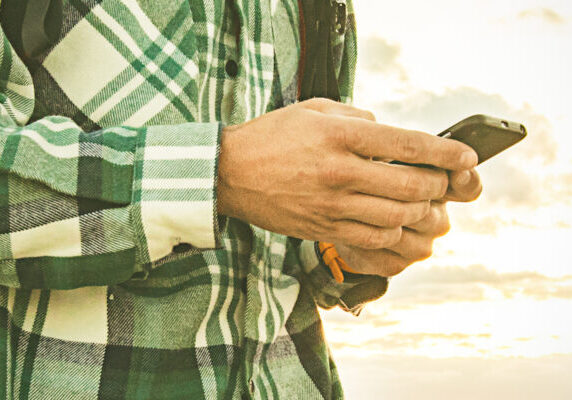 A man in flannel holds his phone